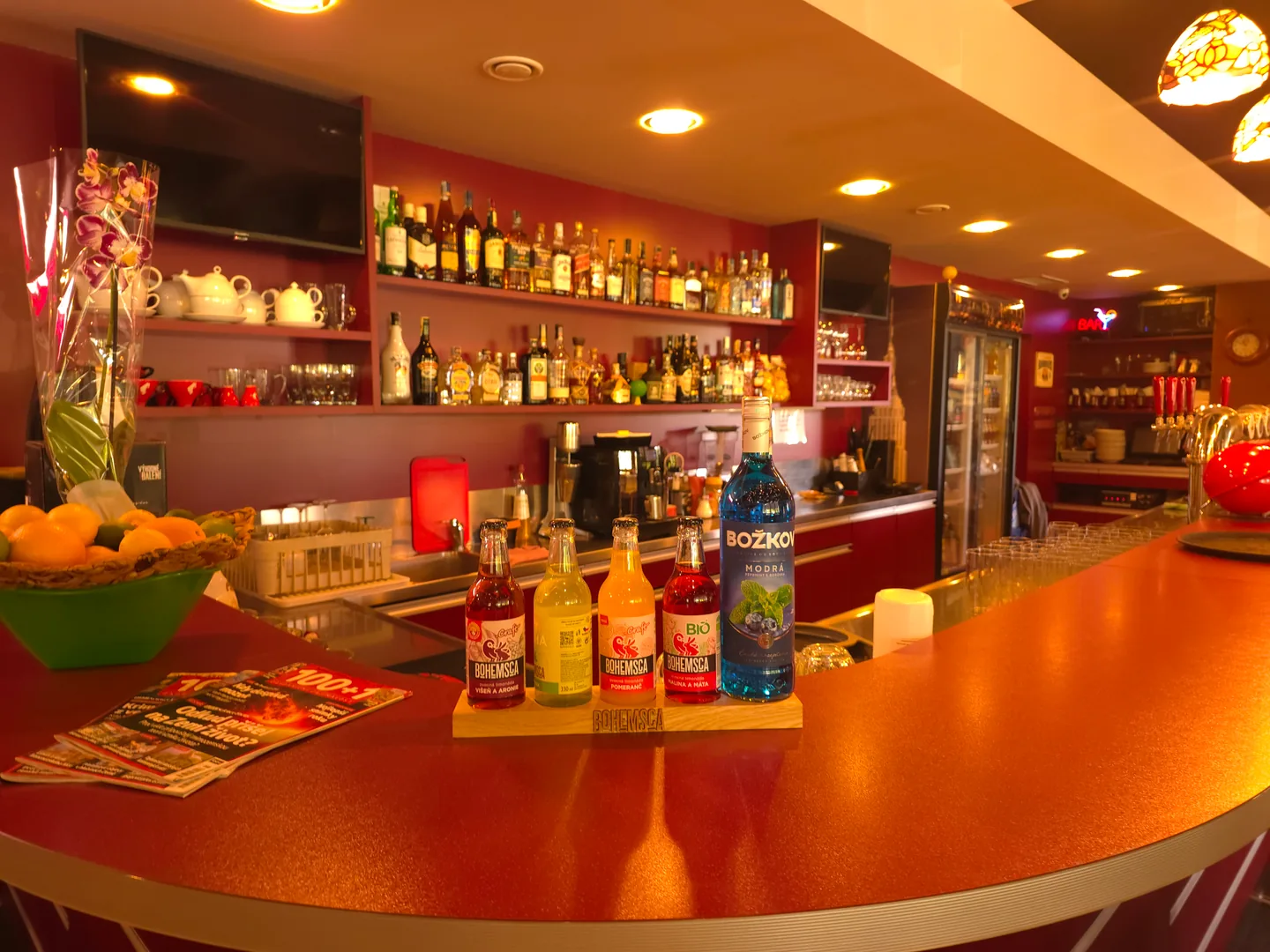 Dlouhý červený bar Saloon Pubu osvětlený závěsnými lampami