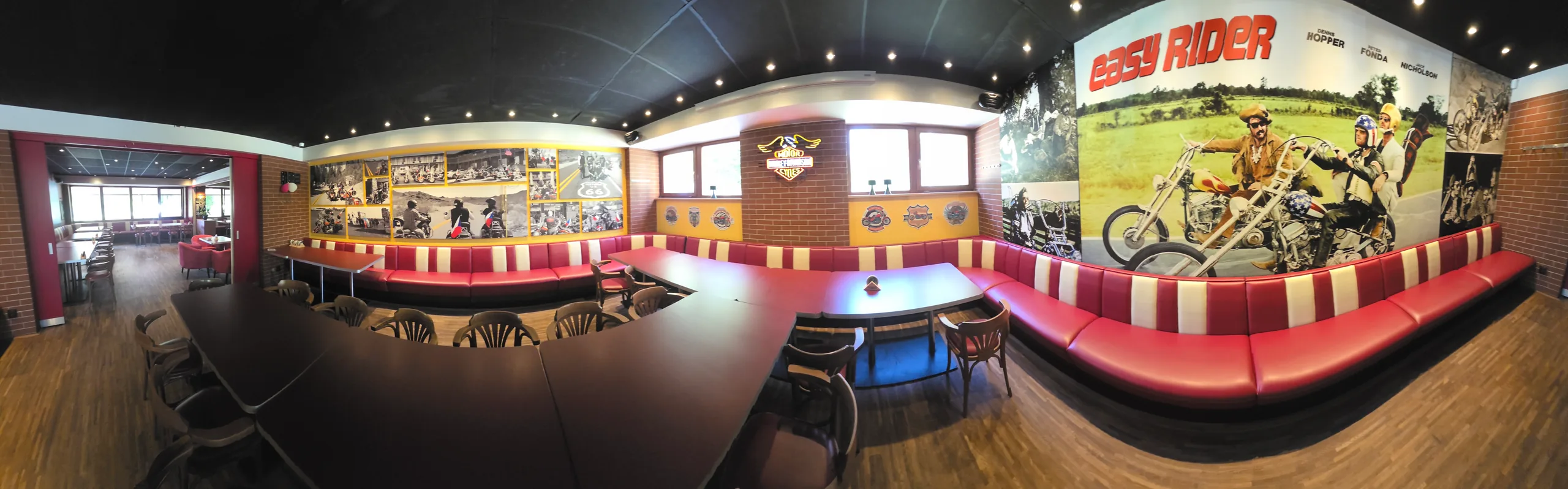 Široké panorama restaurace od baru po červené boxy